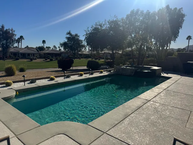 a swimming pool with patio outdoor seating and yard