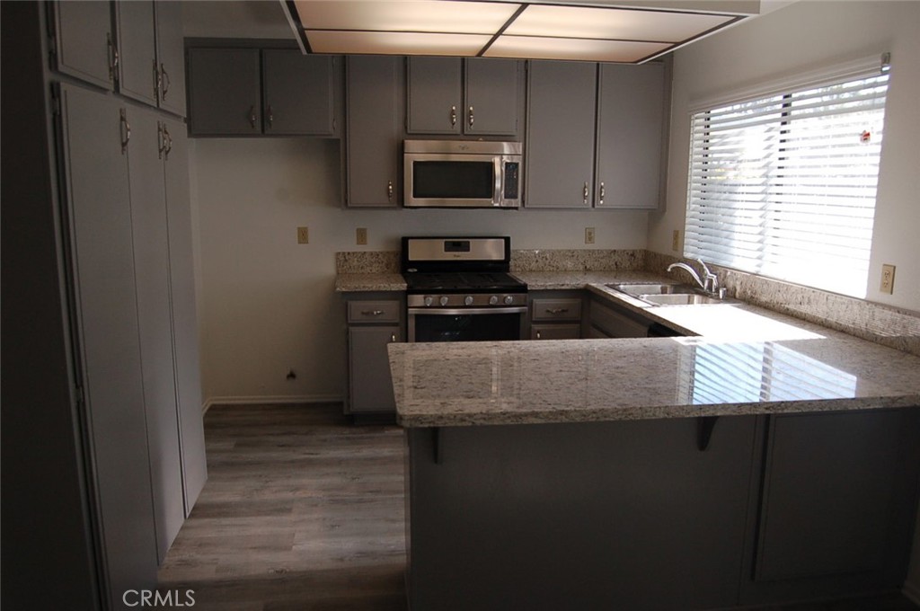 47 Deer Creek Road Phillips Ranch, CA 91766 - Photo 10 of 24 a kitchen with granite countertop a stove and a microwave
