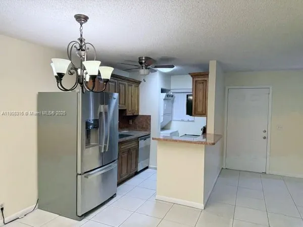 a kitchen with stainless steel appliances granite countertop a sink and a refrigerator