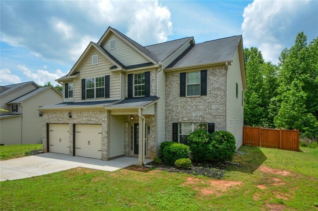 917 Revere Way Hampton, GA 30228 - Photo 2 of 25 a front view of a house with a yard and garage