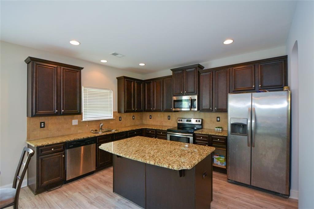917 Revere Way Hampton, GA 30228 - Photo 7 of 25 a kitchen with granite countertop stainless steel appliances and wooden cabinets