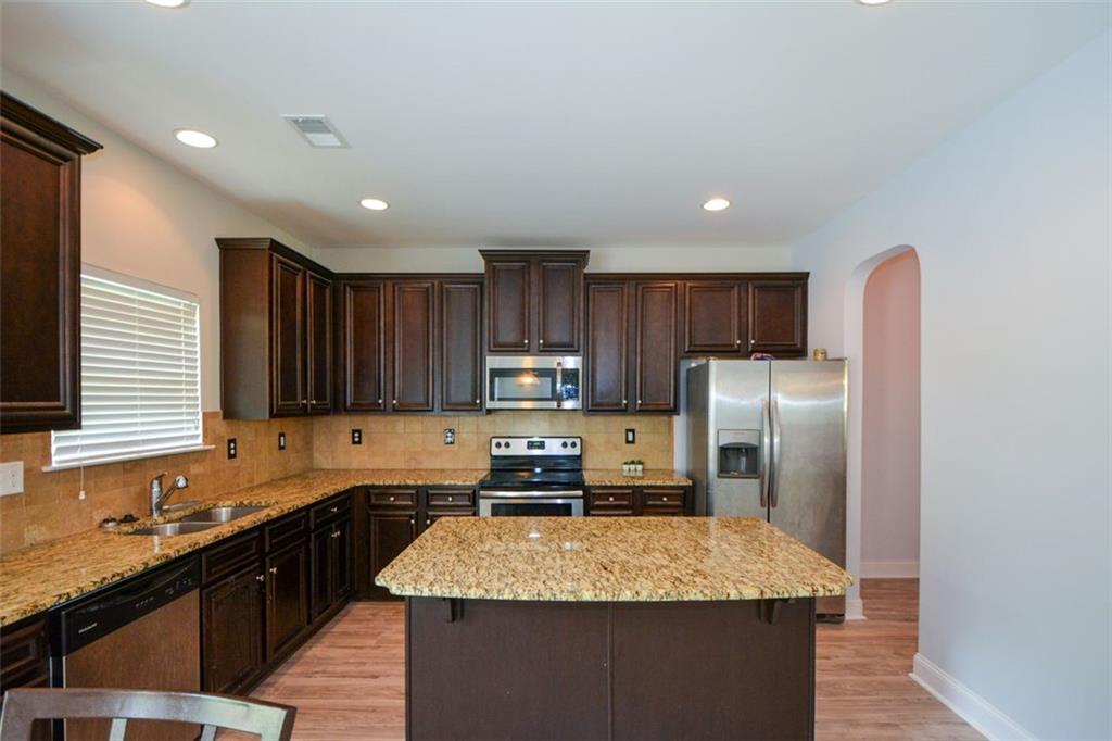 917 Revere Way Hampton, GA 30228 - Photo 8 of 25 a kitchen with stainless steel appliances granite countertop a refrigerator stove top oven and sink