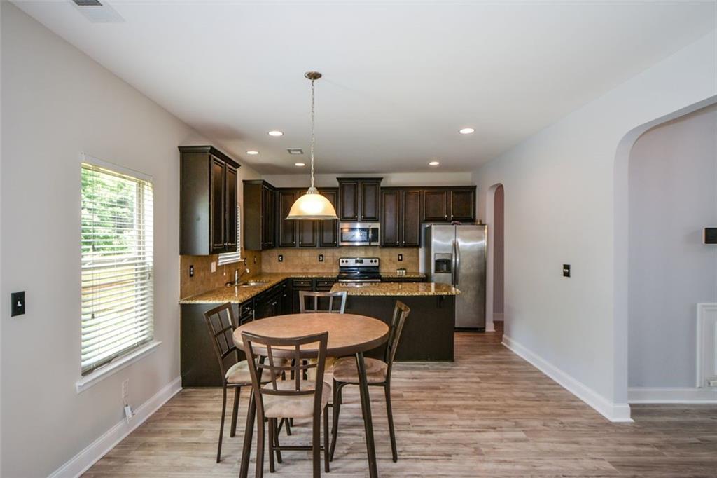 917 Revere Way Hampton, GA 30228 - Photo 9 of 25 a kitchen with a dining table chairs and wooden floor