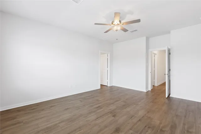 a view of a room with wooden floor closet and fan