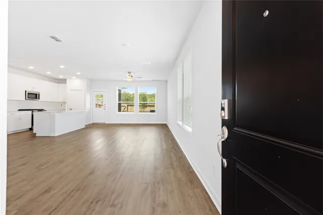an empty room with wooden floor and windows
