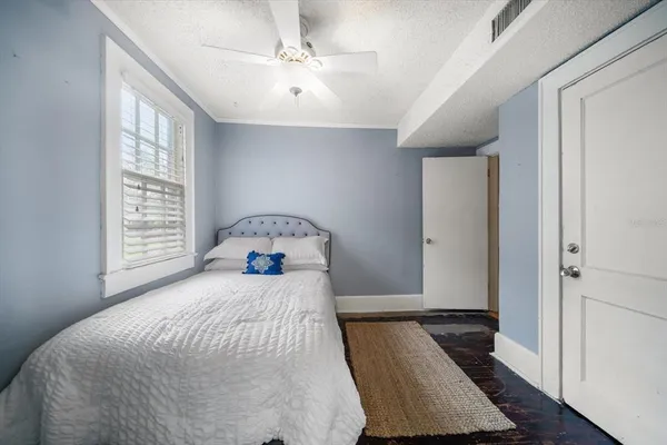 a bedroom with a bed and wooden floor