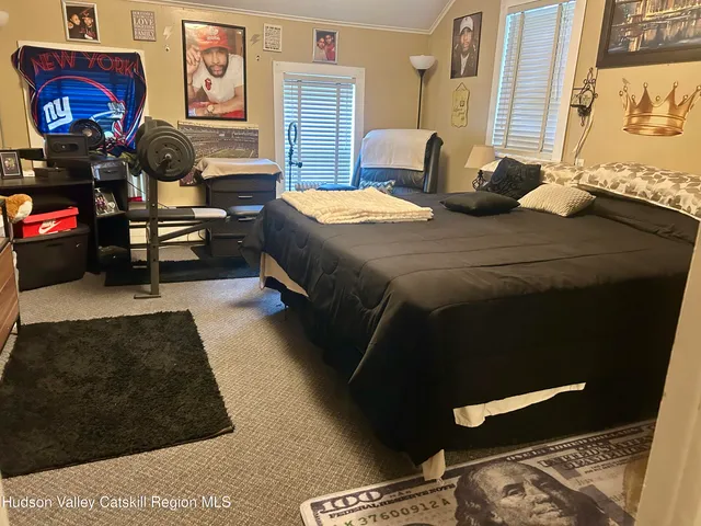 a bedroom with a bed and dresser next to a window