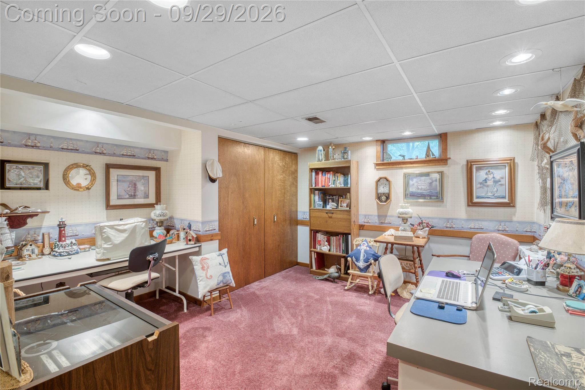 6411 Farrand Road Clio, MI 48420 - Photo 24 of 33 Recessed lighting illuminates this versatile space featuring wood-paneled closet doors, built-in shelving, and a drop ceiling