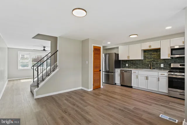 a kitchen with granite countertop a refrigerator and a stove top oven