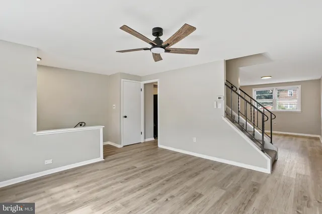 a view of a hallway with wooden floor and stairs