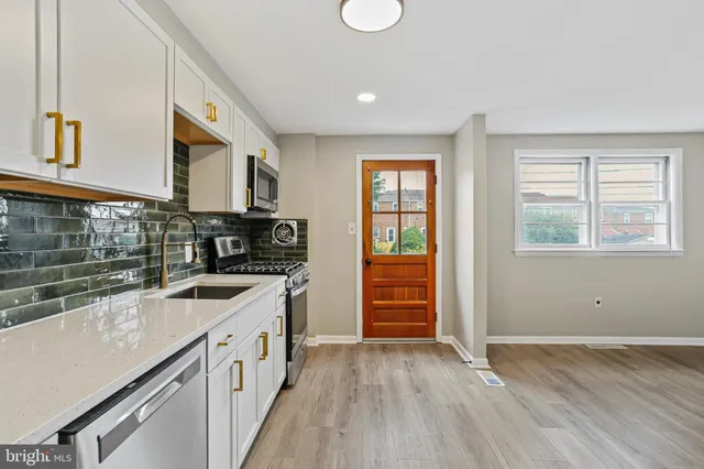a kitchen that has a sink and a stove in it