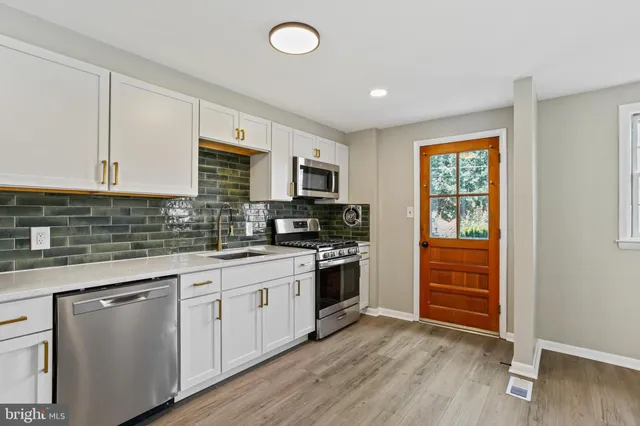 a kitchen with granite countertop a stove top oven a sink dishwasher and a refrigerator with wooden floor