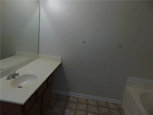 a bathroom with a granite countertop toilet and a sink