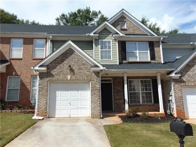 a front view of a house with yard and garage