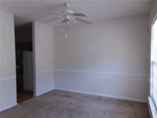 an empty room with a ceiling fan and a window