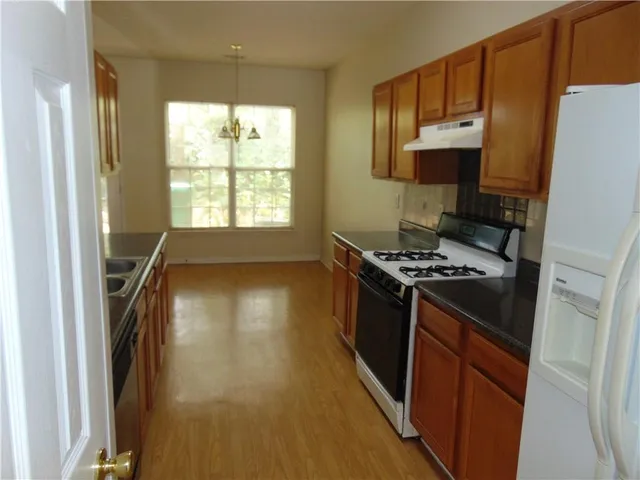 a kitchen with granite countertop a stove and a refrigerator