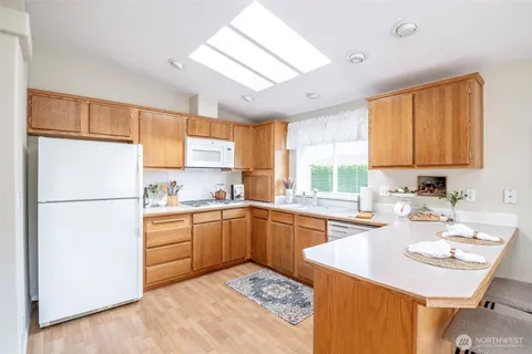 a kitchen with sink refrigerator and large window