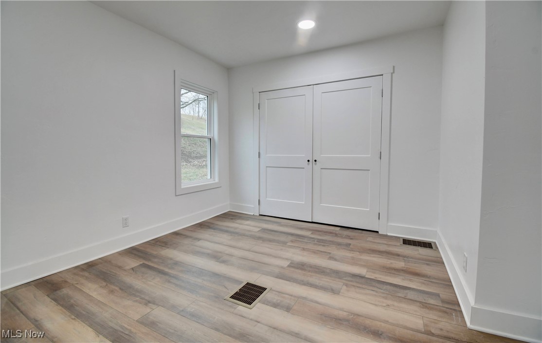 10337 Ragersville Road Southwest Baltic, OH 43804 - Photo 16 of 35 Unfurnished bedroom with light wood-type flooring and a closet