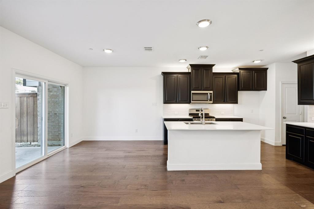 964 Emil Place Allen, TX 75013 - Photo 11 of 25 a kitchen with stainless steel appliances a sink a stove top oven a counter space and cabinets