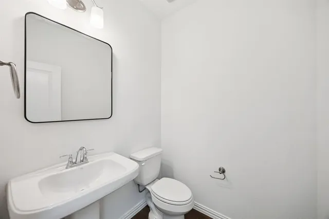 a bathroom with a sink mirror and toilet