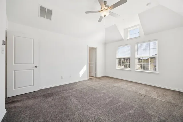 an empty room with windows and ceiling fan