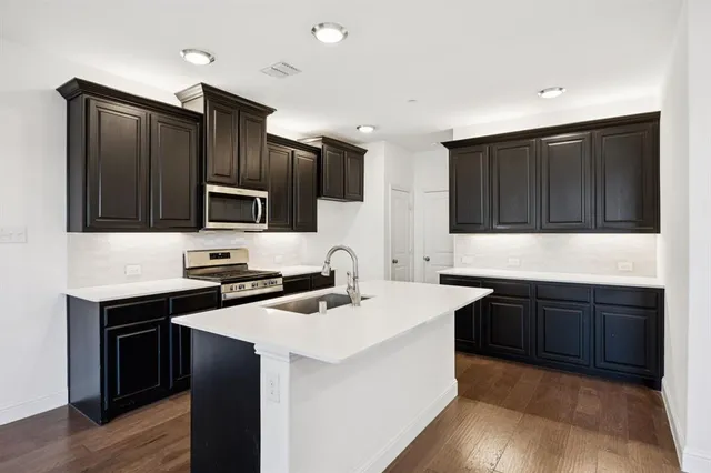 a kitchen that has a sink and a stove top oven