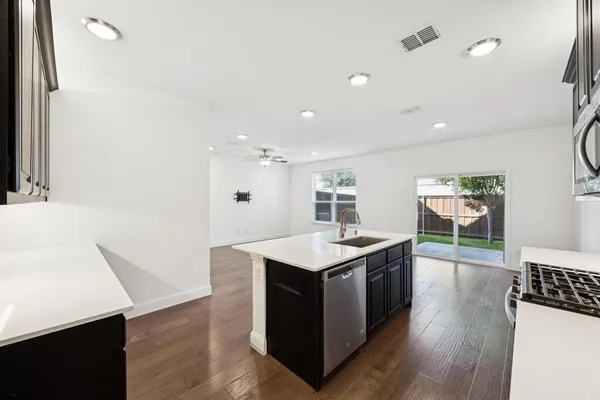 a kitchen with a sink a counter space and wooden floor
