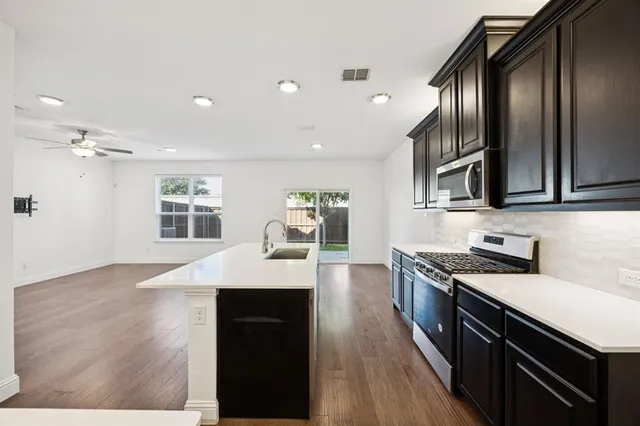 a kitchen with granite countertop cabinets a sink and stainless steel appliances