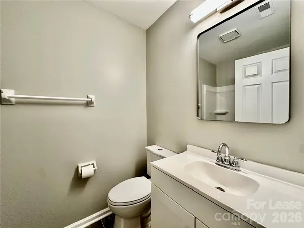 a bathroom with a sink a toilet and mirror