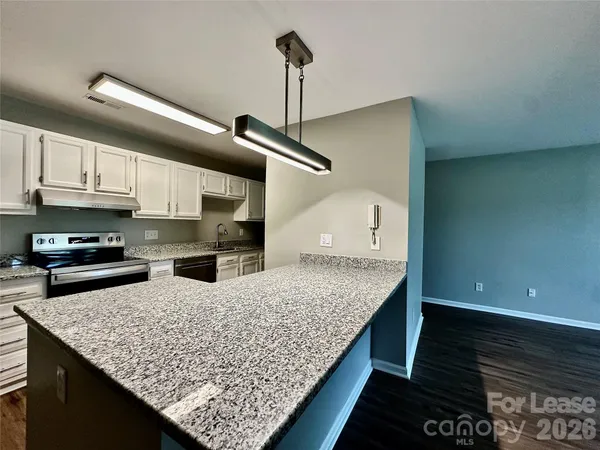 a kitchen with stainless steel appliances granite countertop a sink stove and cabinets