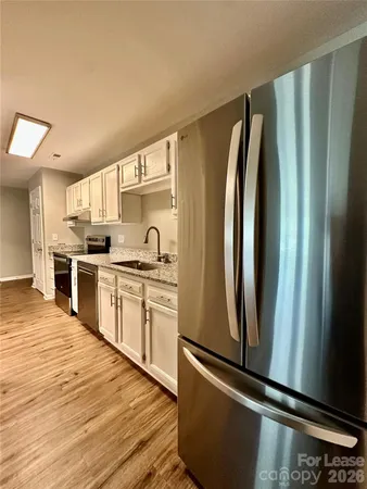 a kitchen with stainless steel appliances granite countertop a refrigerator sink and cabinets