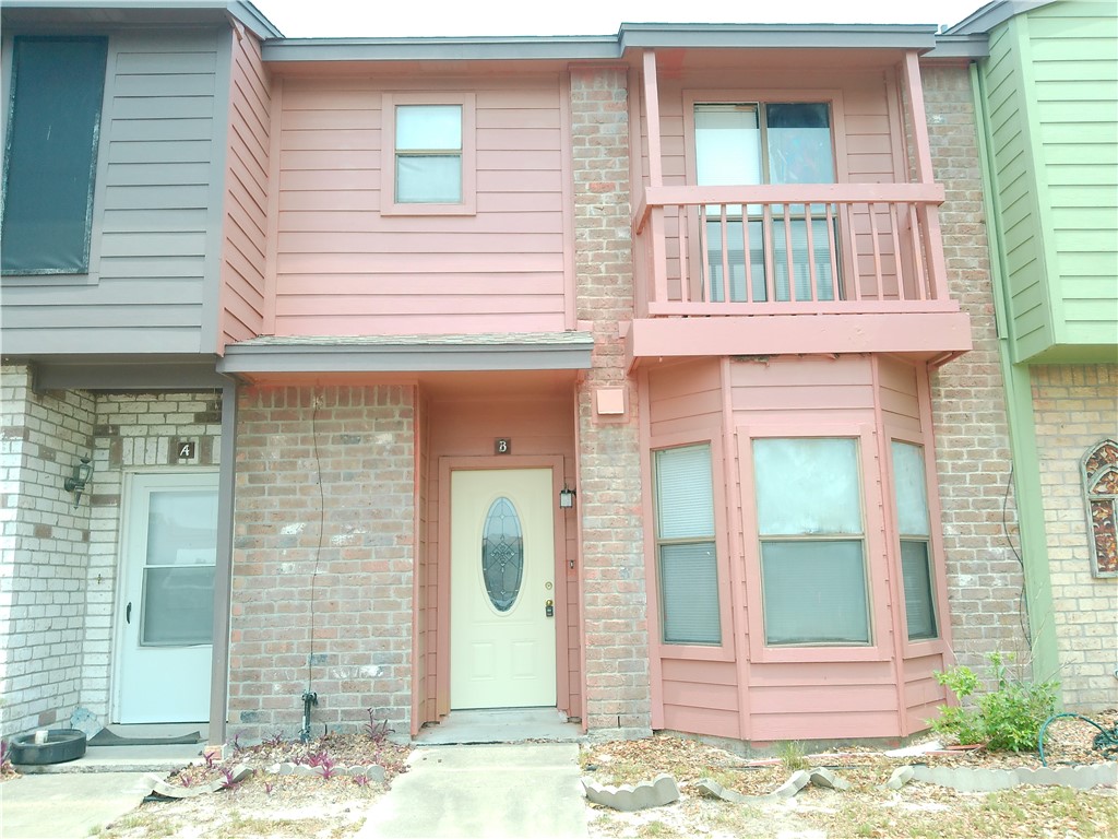 a view of a brick house with large windows