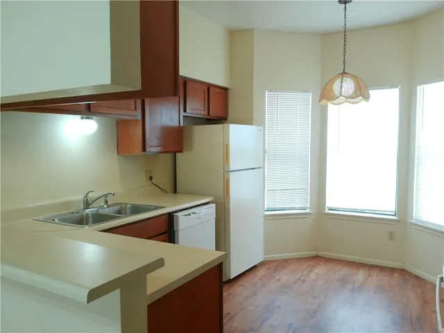 a kitchen with a sink a refrigerator and window