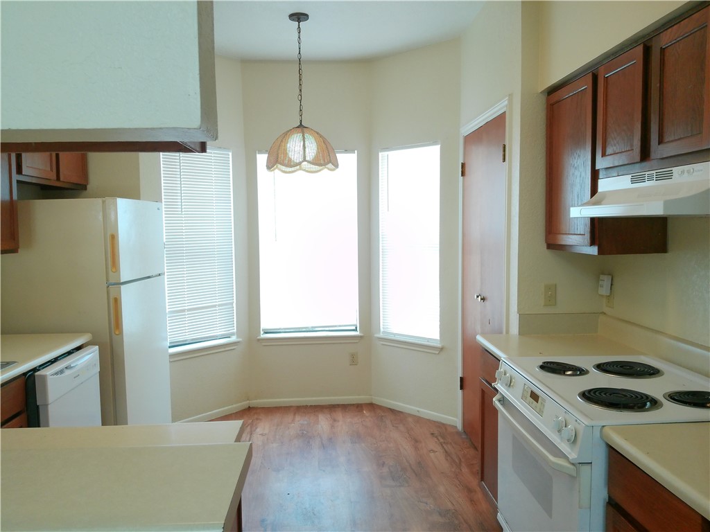 2936 St Joseph Street, Unit B Corpus Christi, TX 78418 - Photo 4 of 15 a kitchen that has a microwave a stove and a refrigerator