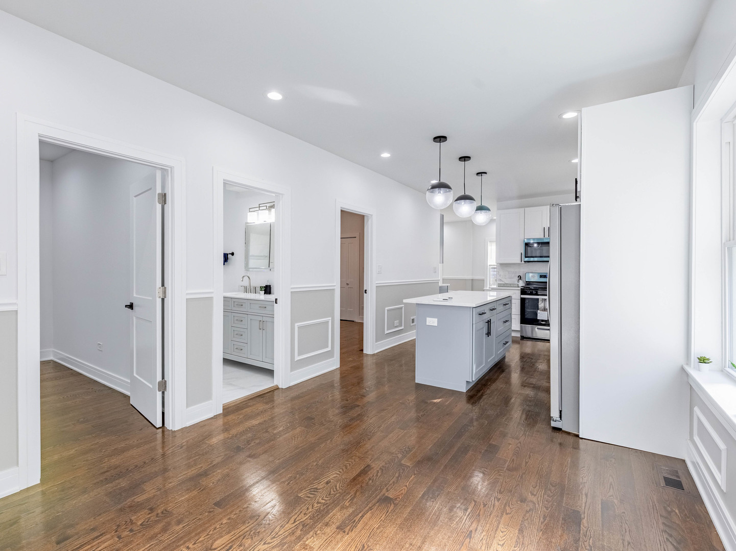 7755 South Wolcott Avenue Chicago, IL 60620 - Photo 5 of 39 a view of a kitchen with kitchen island wooden floor refrigerator and a sink