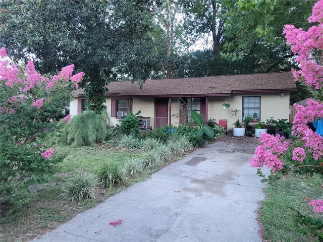 a front view of a house with a yard and fountain