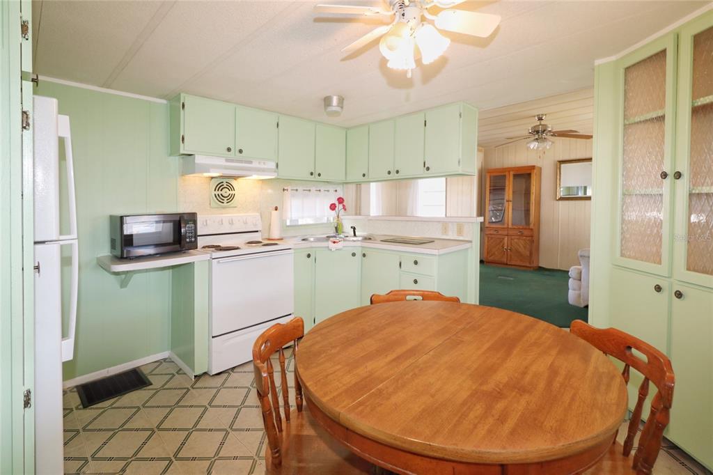 116 West St Johns Way Apollo Beach, FL 33572 - Photo 9 of 28 a kitchen with kitchen island a sink a stove a refrigerator cabinets and dining table