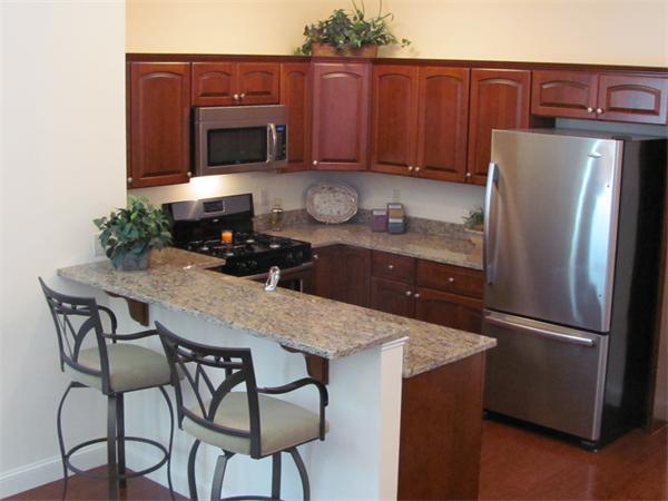 705 Autumn Ridge Drive, Unit 705 Ayer, MA 01432 - Photo 8 of 16 a kitchen with granite countertop a refrigerator stove and microwave