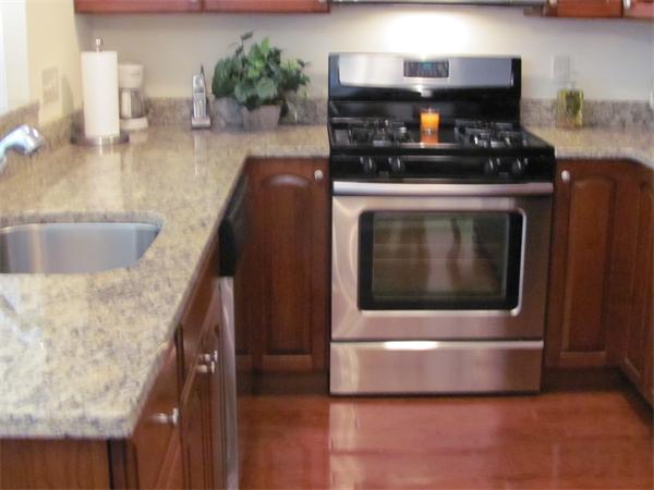 705 Autumn Ridge Drive, Unit 705 Ayer, MA 01432 - Photo 9 of 16 a kitchen with granite countertop a stove and a sink