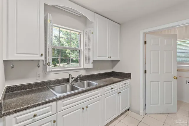 a kitchen with granite countertop white cabinets and window