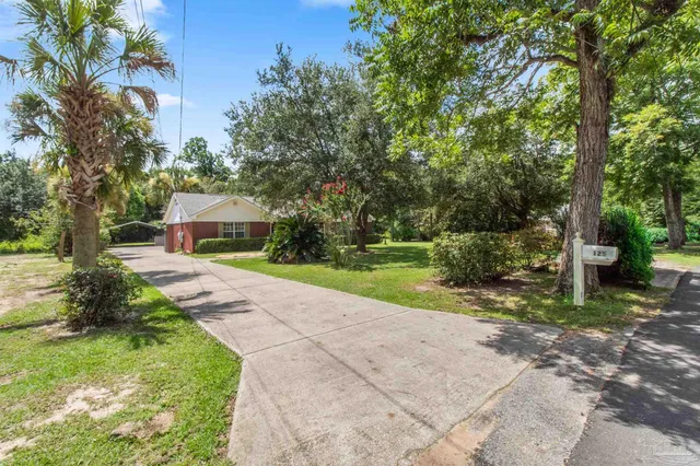 a front view of a house with a yard and tree s