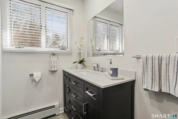 a bathroom with a sink a toilet and mirror