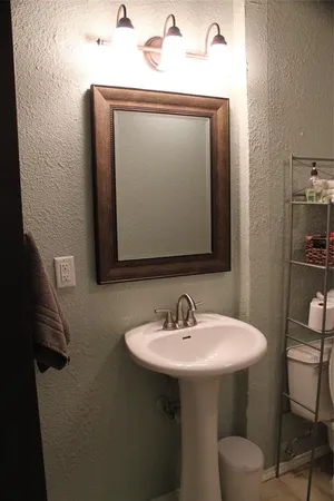 a bathroom with a toilet sink and mirror