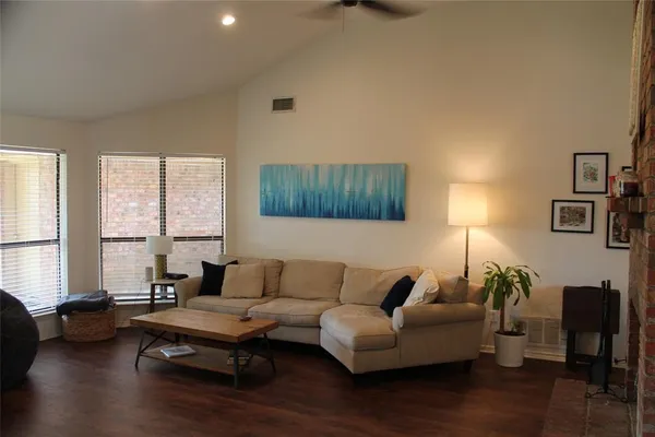 a living room with furniture and a wooden floor