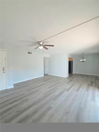 a view of empty room with wooden floor