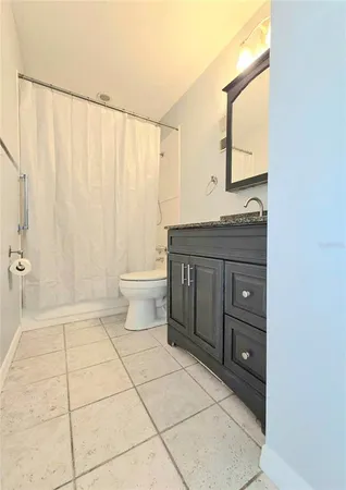 a bathroom with a granite countertop sink a toilet and a mirror