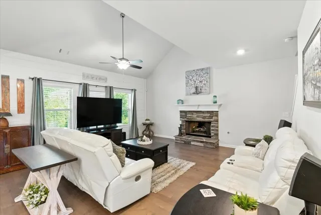 a kitchen with stainless steel appliances granite countertop a sink a stove a refrigerator cabinets and chairs