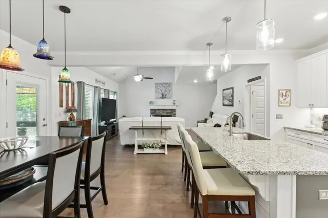 a kitchen with a stove a kitchen island a dining table and chairs