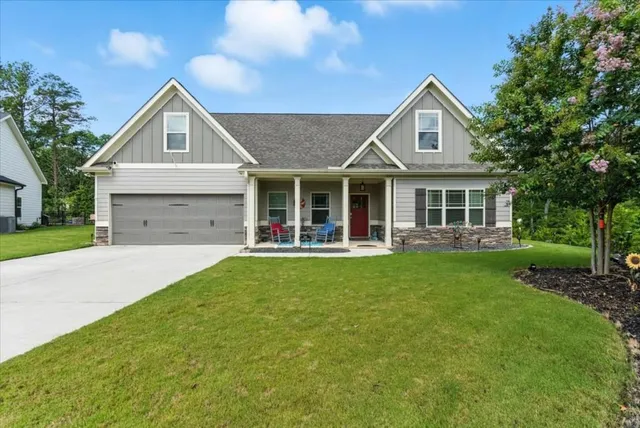 a front view of a house with a garden and yard