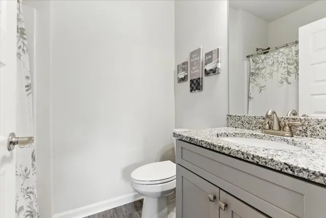 a white toilet sitting in a bathroom next to a window